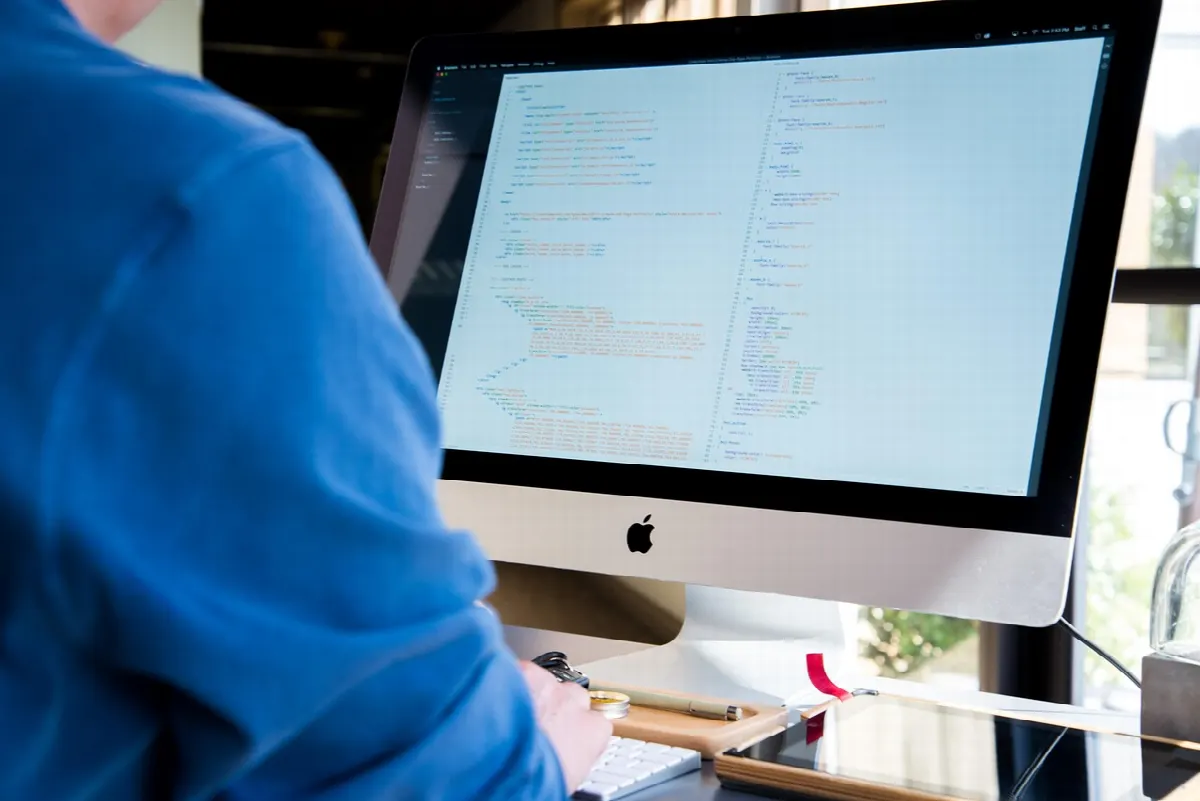 Équipe en réunion autour d'ordinateurs pour revue de code